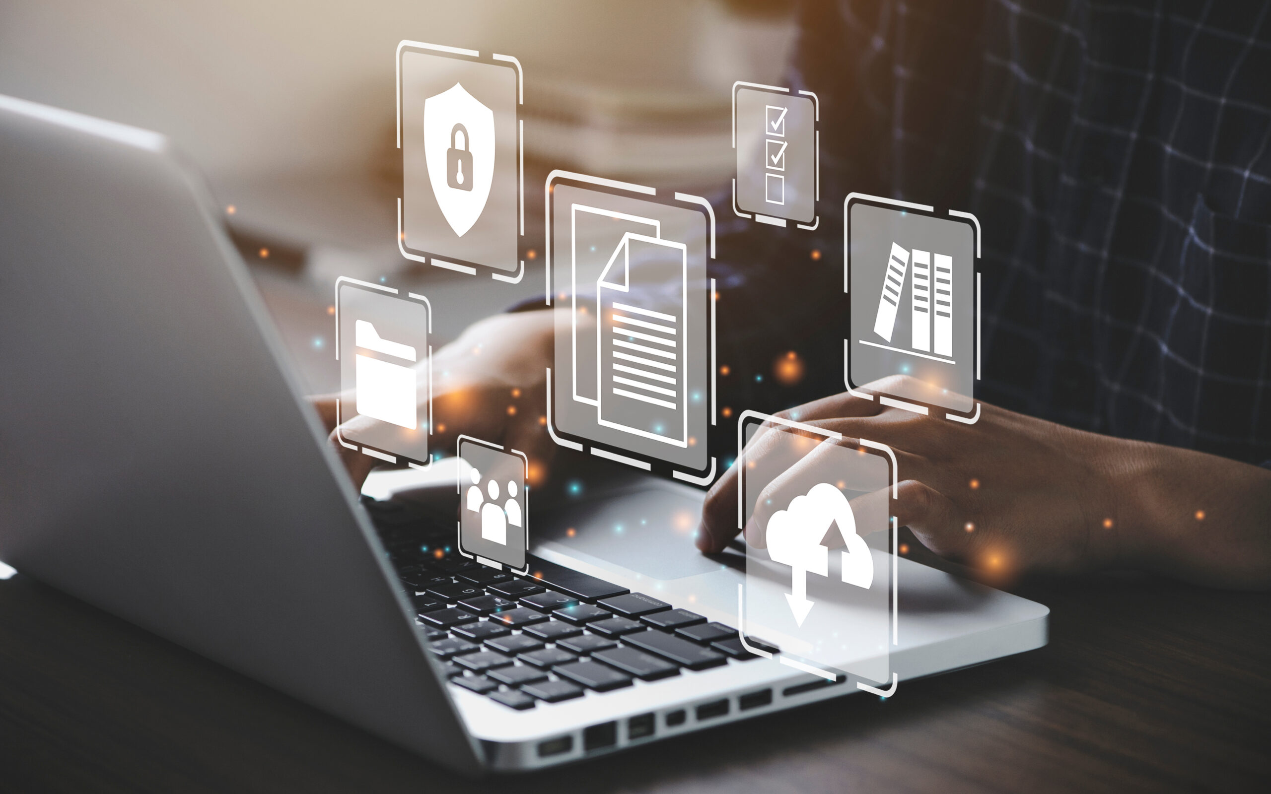 Hands typing on a laptop with cybersecurity and data protection icons overlaying, including file, shield, and cloud upload symbols.