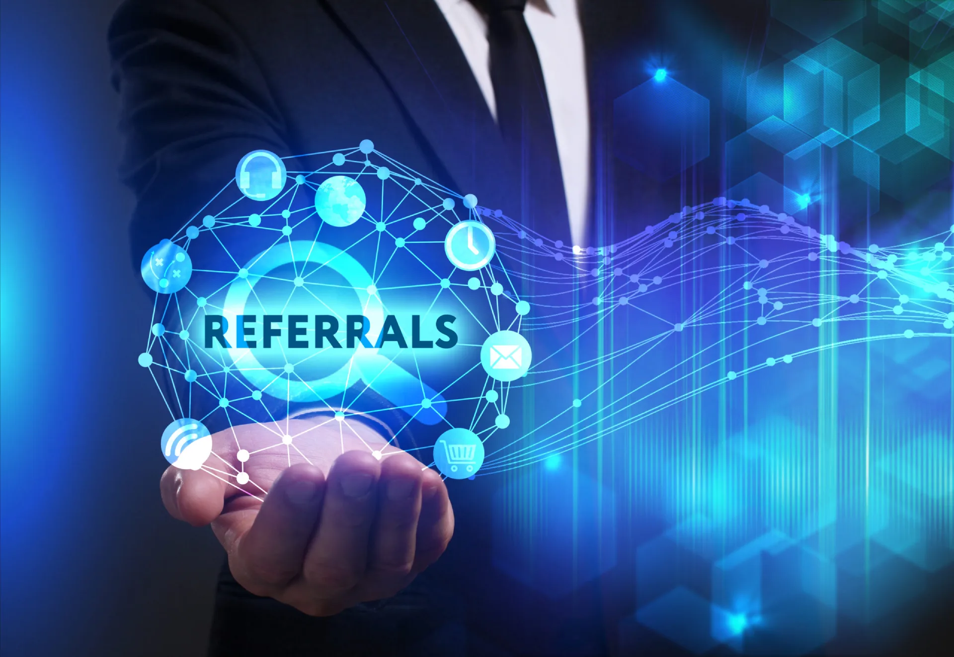 A business professional presenting a digital network graphic with the word "Referrals" surrounded by various technology icons.